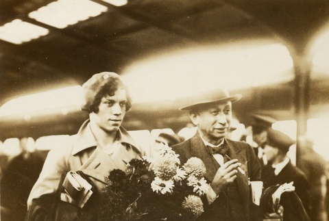 A woman carrying bouquets at train station (ddr-njpa-1-2519)
