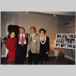 Four people standing by photo collage (ddr-densho-466-543)