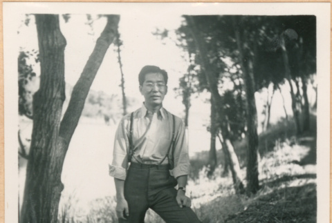 Henri Takahashi posing next to tree (ddr-densho-410-562)
