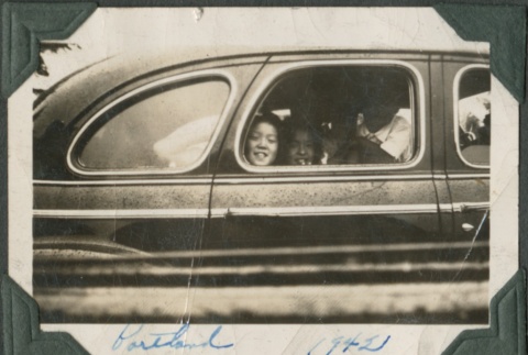 People smile out of car window (ddr-densho-321-22)