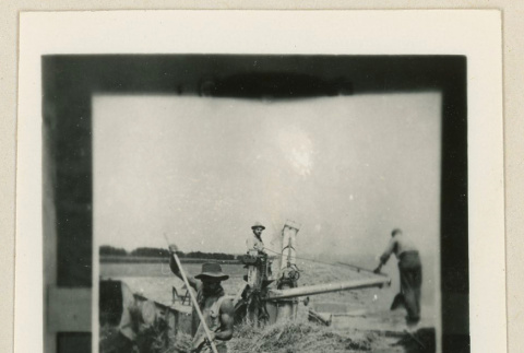 Three men working with agricultural equipment (ddr-densho-37-927)