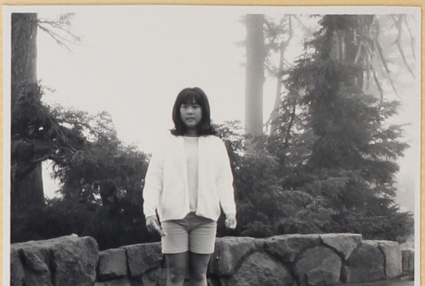 Girl standing by stone wall (ddr-densho-522-118)