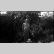 A woman stands in front of bushes (ddr-densho-480-60)