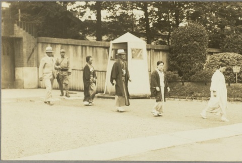A group of men and women walking past a sentry (ddr-njpa-13-1436)