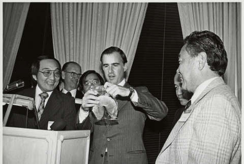 Jerry Brown being gifted a giant fortune cookie (ddr-densho-499-176)