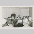 Men and women sitting at tables - Priest standing (ddr-densho-330-282)
