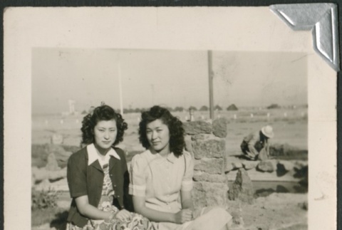 Two young women sittin on a rock (ddr-densho-298-94)