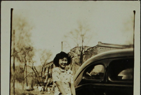 A woman standing next to a car (ddr-densho-328-542)