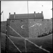 Stone Wall and building behind barbed wire (ddr-densho-329-704)