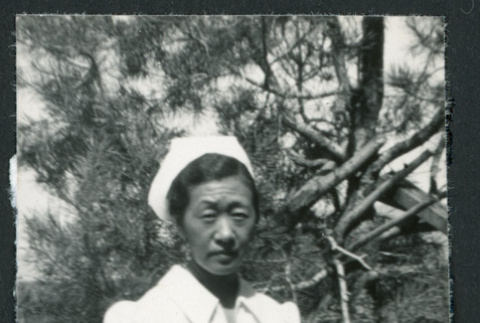 Photograph of Yone Akite, R.N., posing in front of a tree at Manzanar (ddr-csujad-47-189)