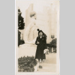 Tomoye Nozawa standing in front of stone statue (ddr-densho-423-472)