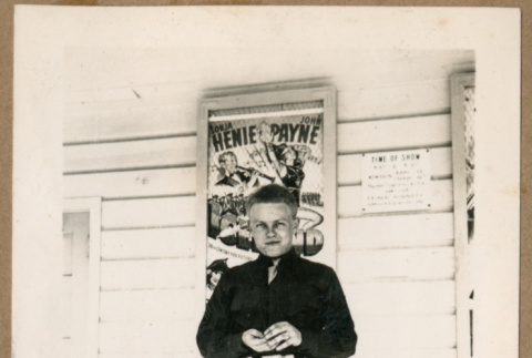 Man standing in front of movie poster (ddr-densho-368-489)
