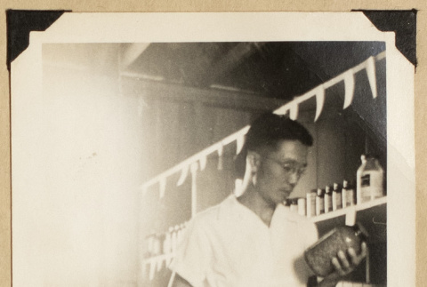 Frank Eya holding a bottle (ddr-densho-542-545)