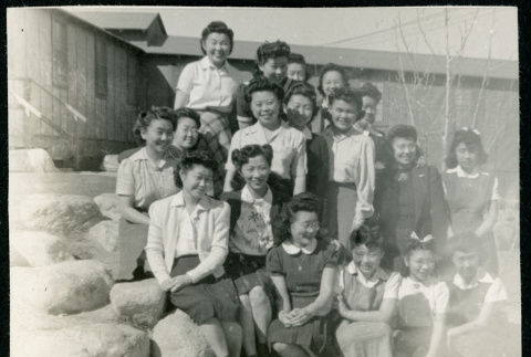 Photograph of a group of women and girls posing on the rocks next to the Manzanar hospital (ddr-csujad-47-211)
