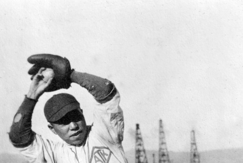 Man in baseball uniform in posed photo titled The Big Wind Up (ddr-ajah-5-61)