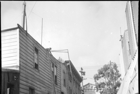 Men working in narrow street with lumber and equipment (ddr-densho-426-2155)