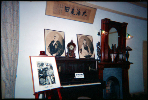 Display of photos, piano and fireplace surround (ddr-densho-426-476)