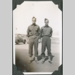 Two men in uniform standing on road (ddr-ajah-2-86)