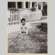 Small child sitting on lawn outside house (ddr-densho-522-17)