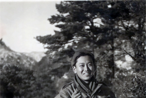 Lloyd Hidemasa Toda standing in snow, eating from mess kit (ddr-densho-474-228)