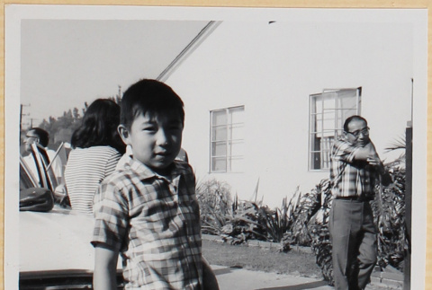 Boy standing by car in driveway (ddr-densho-522-91)