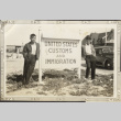 Two men next to US Customs and Immigration (ddr-densho-326-464)