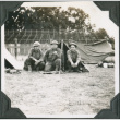 Three men kneeling outside tent (ddr-ajah-2-220)