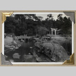 Visitors stroll across two bridges in a Japanese garden (ddr-densho-404-282)