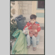 Boy with teddy bear sitting on suitcase (ddr-densho-523-420)