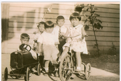 Children playing outside with tricycle and push car (ddr-densho-292-65)