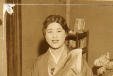 Woman in kimono holding a newspaper (ddr-njpa-4-344)