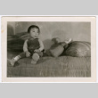 Child sitting on bed (ddr-densho-329-1349)