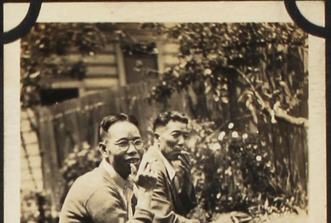 Two men sitting on bench smoking (ddr-densho-423-513)