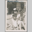 Two children sitting on sidewalk curb (ddr-densho-483-681)