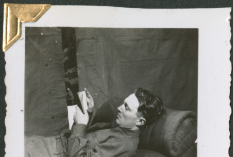 Man laying on cot, reading (ddr-densho-434-64)