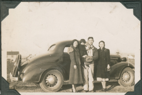 Three adults and girl standing next to car (ddr-densho-316-354)