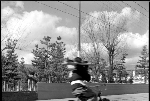 Man riding bicycle while balancing tray (ddr-densho-426-294)