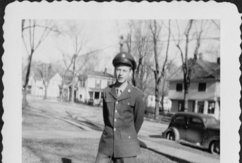 Man in uniform standing by houses (ddr-densho-434-450)