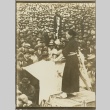 A woman on a raised platform in front of a large crowd (ddr-njpa-13-1454)