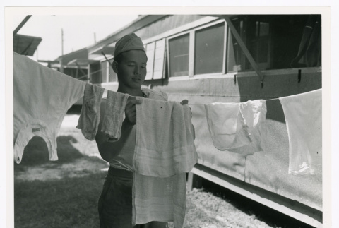 Private William Okawaki hanging laundry (ddr-densho-1007-99)