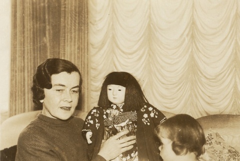 A woman and child showing a Japanese doll (ddr-njpa-1-2243)