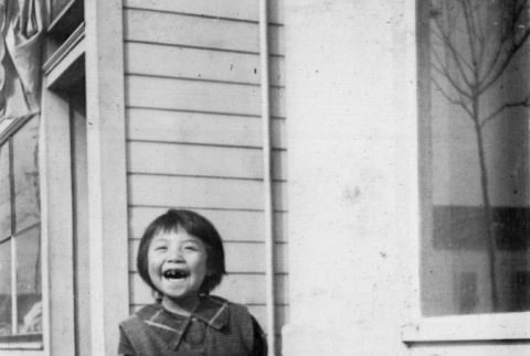 Laughing girl standing on sidewalk (ddr-ajah-6-819)