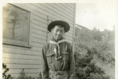 Nisei boy in Boy Scout uniform holding flags (ddr-densho-182-95)