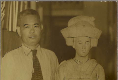 Tosuke Akamine standing next to a statue (ddr-njpa-5-148)