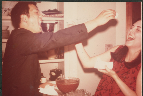 Couple joking around with cake (ddr-densho-523-532)