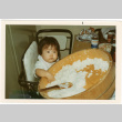 Baby in high chair with large container of rice (ddr-densho-430-193)