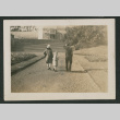 two adults and a child walking toward a building (ddr-densho-378-808)