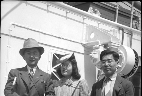 Tomoye (Nozawa) Takahashi in center, Henri Takahashi on right, with unknown man on board ship (ddr-densho-426-1982)