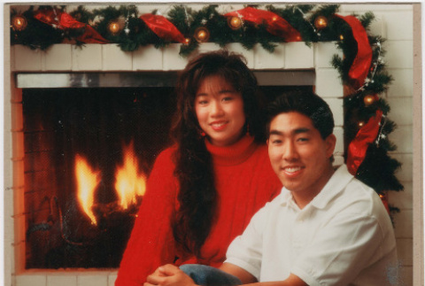 Christmas card with two teens in front of fireplace (ddr-densho-430-258)