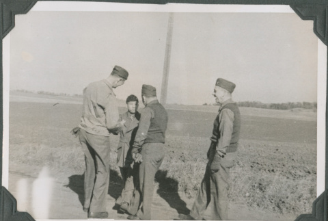 Four men standing on road talking (ddr-ajah-2-446)